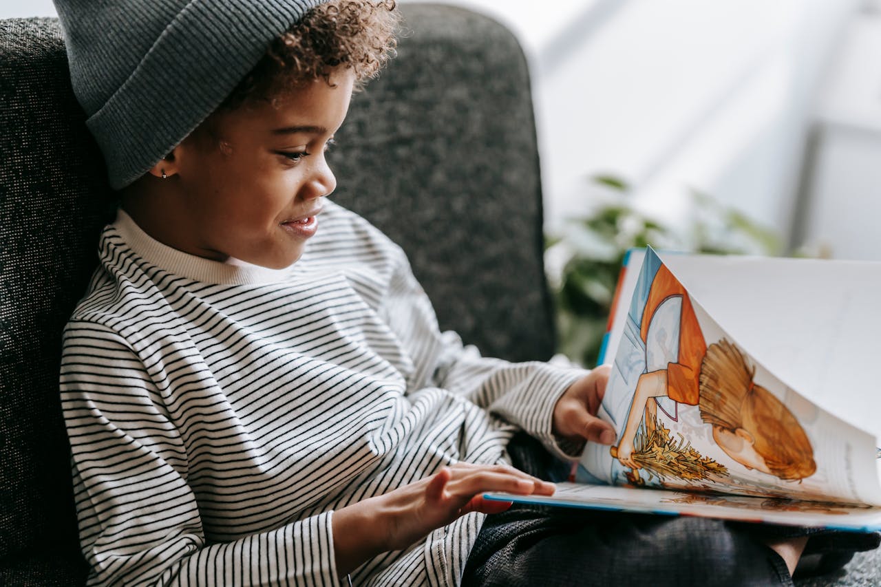 Crafting Captivating Headlines: Your awesome post title goes here Side view of crop glad African American boy with curly hair smiling and watching pictures of book on blurred background